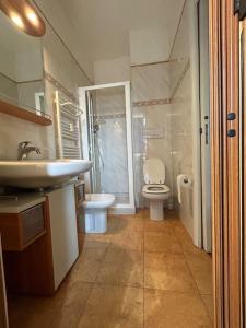 ein Bad mit einem Waschbecken, einem WC und einer Dusche in der Unterkunft Residenza Versilia in Viareggio