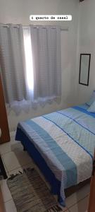 um quarto com uma cama e uma janela em CASA DE PRAIA DO MINEIRO - A 300 metros do MAR em Nova Viçosa