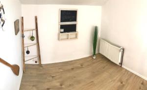 a room with a white wall and a wooden floor at Ferienwohnung Ostseeglück in Neu Jörnstorf