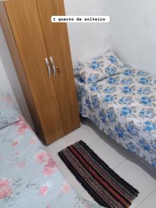 um quarto com uma cama ao lado de um armário de madeira em CASA DE PRAIA DO MINEIRO - A 300 metros do MAR em Nova Viçosa