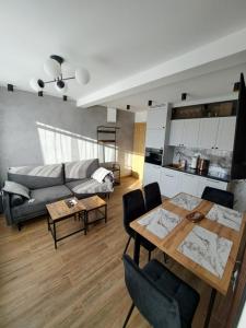 a living room with a table and a couch at Apartament Kluskowe Widoki in Kluszkowce