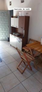 une cuisine avec une table en bois et une chaise dans l'établissement CASA DE PRAIA DO MINEIRO - A 300 metros do MAR, à Nova Viçosa