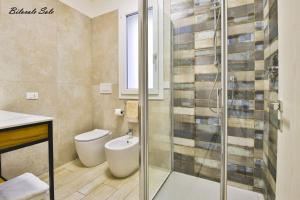 a bathroom with a toilet and a glass shower at Casa Stefania Rimini in Rimini
