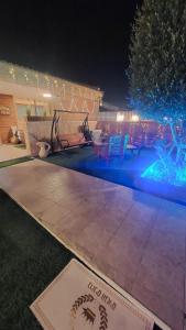 a backyard with a pool at night at עץ הזית דירת אירוח in Yeroẖam