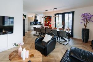 Dutch Design Villa with 6 luxurious bedrooms في أمستردام: غرفة معيشة مع طاولة وغرفة طعام