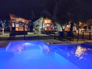 una piscina frente a una casa por la noche en Cabañas Posta Litoral en Colón