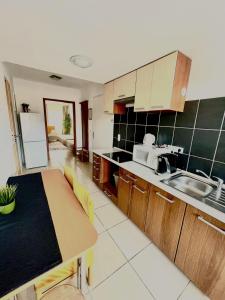 a kitchen with a table and a counter top at Alpesi Apartman in Sopron