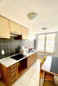 a kitchen with wooden cabinets and a counter top at Alpesi Apartman in Sopron