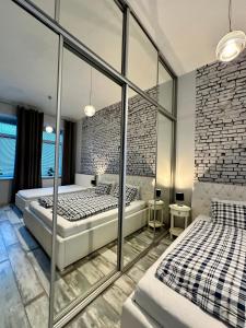 two beds in a bedroom with a brick wall at Royal City Centre Apartment in Poprad