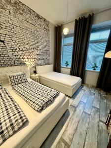 a bedroom with two beds and a brick wall at Royal City Centre Apartment in Poprad