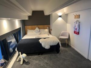 a bedroom with a large bed and a chair at Flaine Forum G1 Cassiopée Mezzanine & Terrasse in Flaine