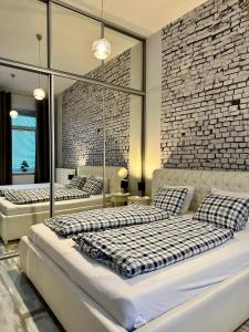 two beds in a room with a brick wall at Royal City Centre Apartment in Poprad