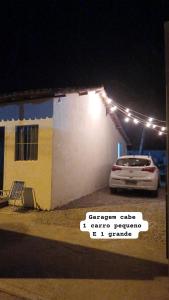 une voiture garée devant un bâtiment la nuit dans l'établissement CASA DE PRAIA DO MINEIRO - A 300 metros do MAR, à Nova Viçosa