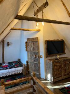 a bedroom with a tv and a bed in a tent at Casa Colț din Maramureș - Old Traditional House in Ocna Şugatag