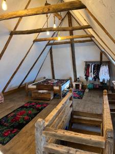 Pokój na poddaszu z 2 łóżkami i dywanami w obiekcie Casa Colț din Maramureș - Old Traditional House w mieście Ocna Şugatag