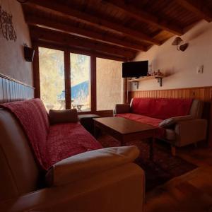 a living room with a couch and a table at LE NID ROUDELA in Garin