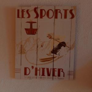 a sign hanging on a wall with a dog on skis at LE NID ROUDELA in Garin