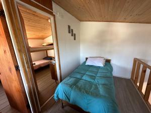 małą sypialnię z łóżkiem i pokojem piętrowym w obiekcie Cabañas Sal & Arena w mieście El Quisco