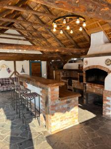 a bar in a room with a fireplace and stools at Casa Colț din Maramureș - Old Traditional House in Ocna Şugatag