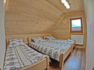 a bedroom with two beds in a wooden cabin at Domki na Wzgórzu in Piekielnik