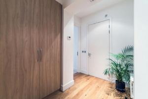 a hallway with a wooden door and a potted plant at StayInn Aldgate East in London