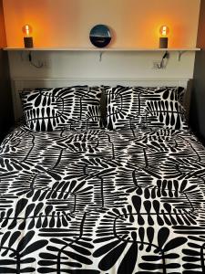 a bed with a black and white comforter and pillows at Moderno Appartamento - Anzio in Anzio