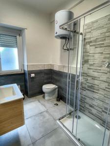 y baño con ducha, aseo y lavamanos. en Moderno Appartamento - Anzio, en Anzio