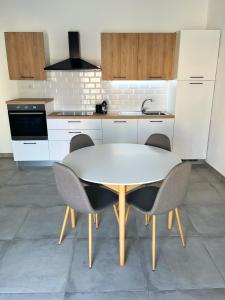 a kitchen with a white table and chairs in it at Moderno Appartamento - Anzio in Anzio