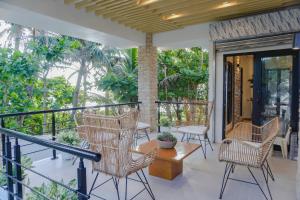 un porche con mesa y sillas de mimbre en Villa Ferrer, en Mahatao