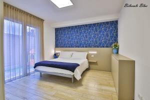 1 dormitorio con cama y pared de acento azul en Casa Stefania Rimini, en Rímini