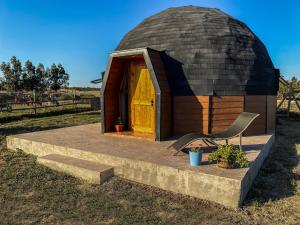 una pequeña casa en la cúpula con una silla delante de ella en Domo ruta del vino Colchagua, en Peralillo