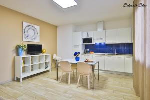 a kitchen with white cabinets and a table and chairs at Casa Stefania Rimini in Rimini