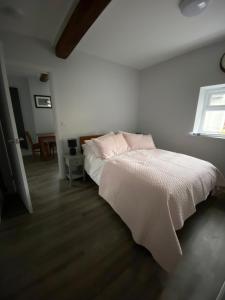 1 dormitorio con cama blanca y ventana en The Old Barn one bedroom apartment in Overton, en Overton