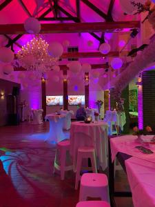 um quarto com mesas e cadeiras e iluminação roxa em B & B M 3 em Merkelbeek