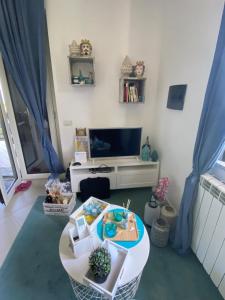 ein Wohnzimmer mit einem Tisch und einem TV in der Unterkunft Villa NOVE - Residence dei Fiori in Zambrone