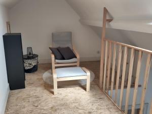 a living room with a chair and a stair case at Le Patenier in Dinant