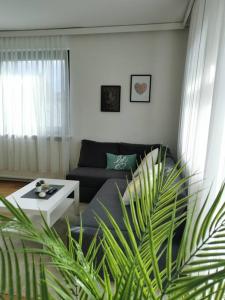 a living room with a couch and a table at Wörthersee: Gemütliche Wohnung in Klagenfurt