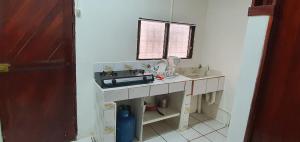 a kitchen with a sink and a counter top at Hotel Allan Veintiocho Puntarenas in Puntarenas