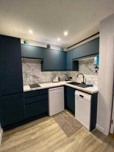 a kitchen with blue cabinets and a sink at The Old Barn one bedroom apartment in Overton in Overton