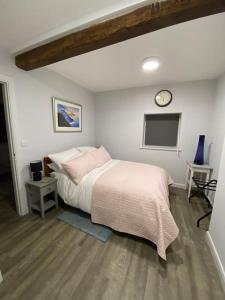 1 dormitorio con 1 cama y reloj en la pared en The Old Barn one bedroom apartment in Overton, en Overton