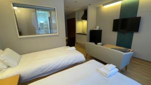 Habitación de hotel con 2 camas y TV de pantalla plana. en WHITE HOTEL GRAND HAKUBA, en Omachi