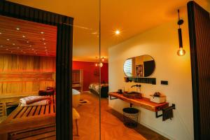 y baño con bañera, lavabo y espejo. en Der Schwarzbau - Luxus Ferienhaus mit Pool und Sauna, en Runding