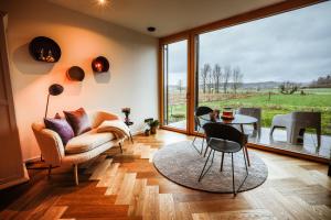 sala de estar con sofá y mesa con sillas en Der Schwarzbau - Luxus Ferienhaus mit Pool und Sauna, en Runding