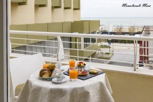 a tray of food on a table on a balcony with orange juice at Casa Stefania Rimini in Rimini