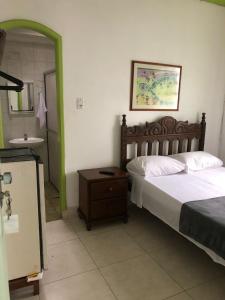 Pousada Coco Verde في باراتي: غرفة نوم بسرير ومغسلة ومرآة