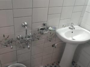 uma casa de banho com um lavatório e um WC em Coorg klusters estate stay em Virajpet