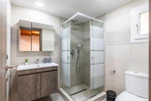 een badkamer met een douche, een toilet en een wastafel bij Irene's Paradise apartments in Skopelos Town