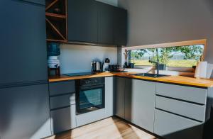una cocina con electrodomésticos de acero inoxidable y una ventana en Seashore Holiday House, en Saraiķi