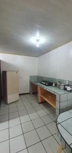 a large kitchen with a counter and a refrigerator at Hotel Allan Veintiocho Puntarenas in Puntarenas