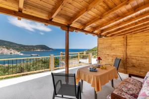 een tafel en stoelen op een balkon met uitzicht op de oceaan bij Irene's Paradise apartments in Skopelos Town